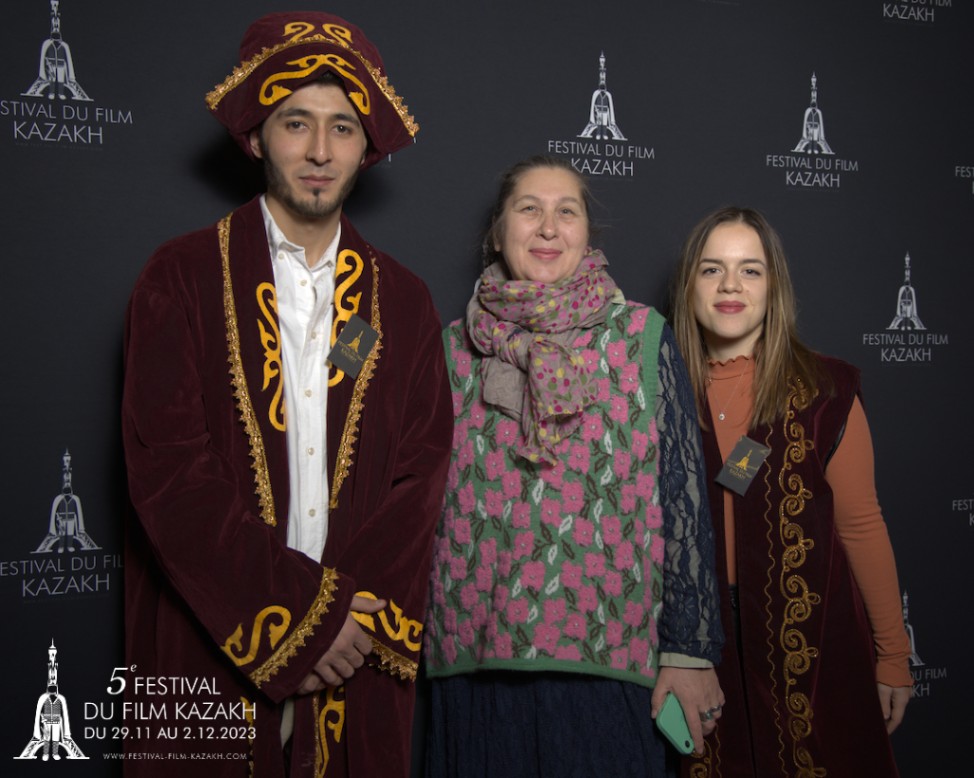 3 personnes qui posent devant un photocall à un évènement de cinéma