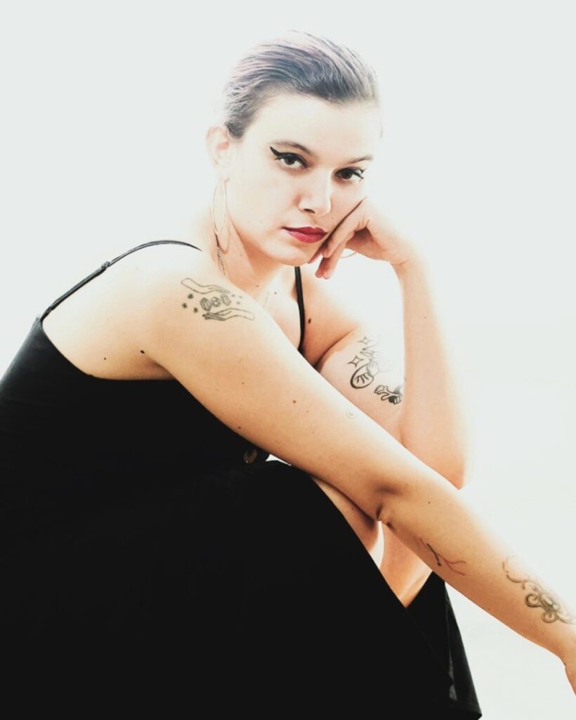 femme qui est accroupie et pose sa tête sur sa main